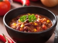 mexican chili con carne in black plate with ingredients
