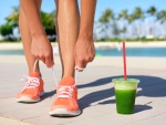 Running woman runner with green vegetable smoothie.  Fitness and healthy lifestyle concept with fema